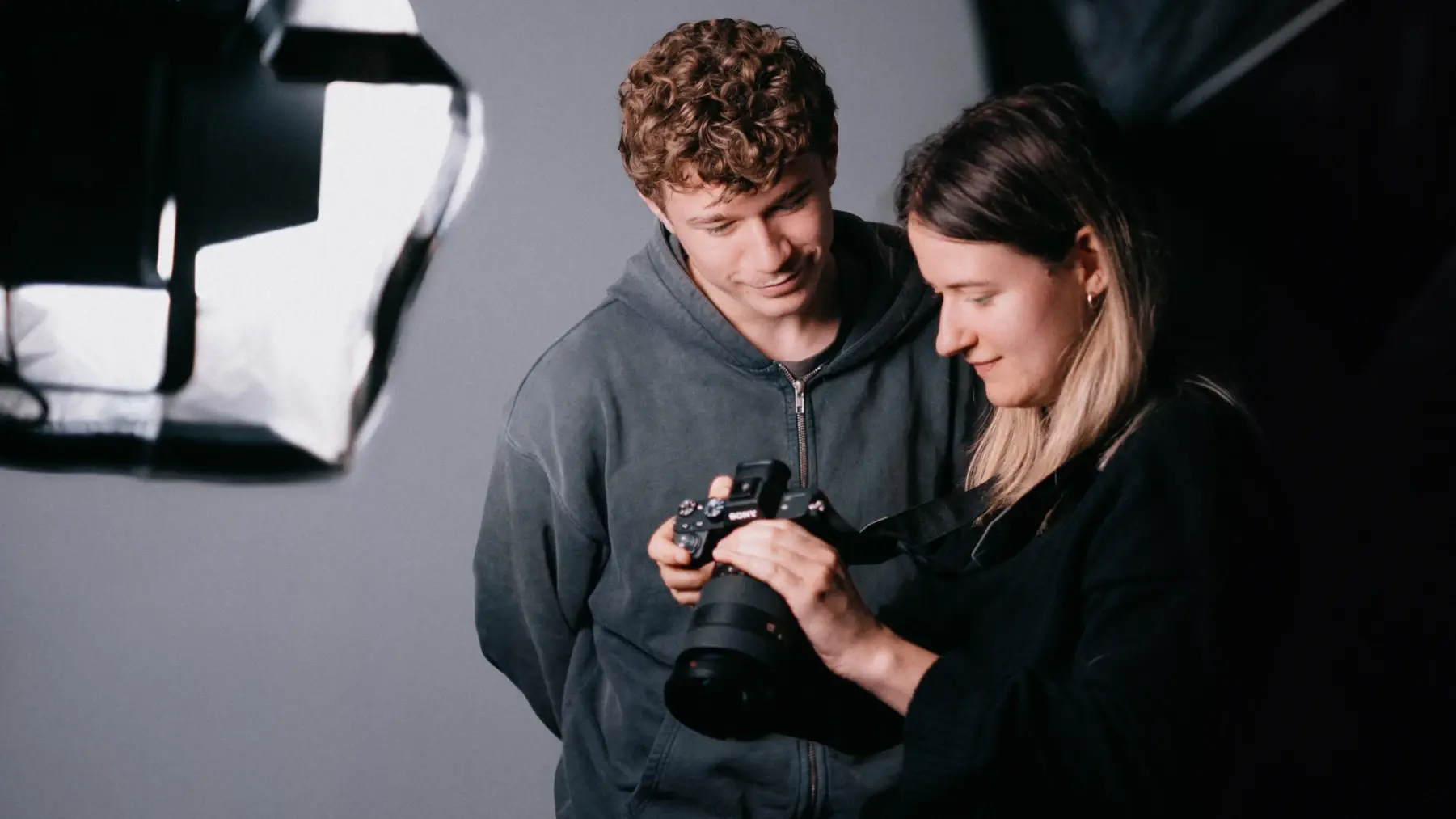 Zwei Mitarbeitende der Content Marketing Agentur pruefen Aufnahmen im Studio